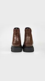 Botas Chelsea de cuero color marrón con elástico lateral negro y suela track negra.