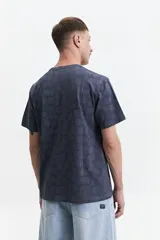Remera blanca con estampado abstracto en tonos grises, de manga corta, corte regular y cuello redondo.