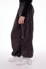 Pantalón wide leg impermeable negro con estampado de logos. Tiene bolsillos laterales ocultos, bolsillos en piernas y en posterior. Tiene tanca en ruedo para ajustar.