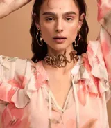 Vestido largo de chiffon con estampado floral en tonos rosados y beige. Tiene escote en V con lazo ajustable, mangas largas abullonadas con volados y forro interior.