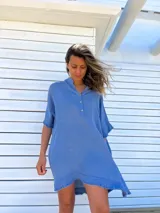 Túnica celeste de lino rústico, corte holgado, cuello en V con botones y ruedo irregular con flecos.