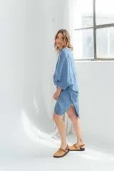 Vestido blanco de lino, corte holgado, con cuello camisero, mangas 3/4 y aberturas laterales.