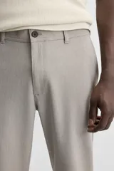 Pantalón de vestir gris oscuro, corte slim fit, con bolsillos laterales y traseros con botón.