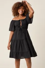 Vestido corto blanco con escote bardot, cintura fruncida y falda escalonada con vuelo.