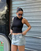 Minifalda de jean celeste con efecto lavado, tiro bajo y bolsillos delanteros y traseros.