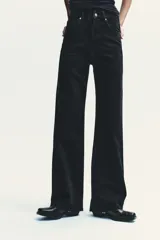 Pantalón de jean azul oscuro, de tiro alto, corte wide leg y largo hasta el tobillo.