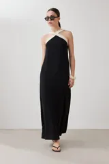Maxi vestido negro con escote halter cruzado en color crema.