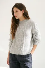 Sweater color arena de tejido de punto con cuello redondo y mangas largas con flecos.