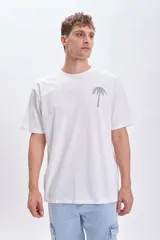 Remera blanca de manga corta con corte oversize y estampa en la espalda con palmeras y texto "Nicoya Peninsula".