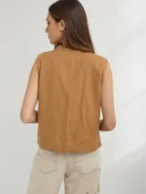 Chaleco color caramelo confeccionado en lino, de corte relajado y con bordado de una mariquita en el frente.