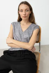 Top sin mangas color plateado con escote en V, completamente cubierto de lentejuelas.