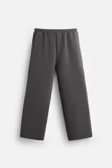 Pantalón jogger wide fit color gris oscuro, confeccionado en tejido de algodón compacto con elasticidad. Cuenta con cintura elástica ajustable con cordón, pliegues frontales, bolsillos delanteros y bolsillo trasero de parche.