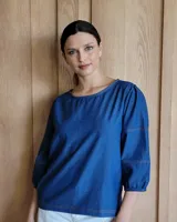 Blusa de mangas 3/4 color azul denim, con cuello redondo y costuras a la vista en color ocre.