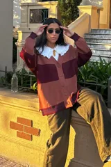 Cárdigan oversized negro con bloques de color rojo en mangas y frente, logo bordado en el pecho y logo texturizado en la espalda.
