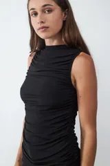 Top básico negro sin mangas con cuello redondo y diseño drapeado.