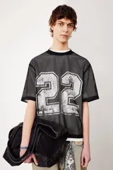 Remera negra de malla con cuello redondo ribeteado y estampado del número 22 en plateado. Corte oversized con hombros caídos y bajo recto.
