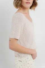 Remera tejida color blanco, con escote en V y mangas cortas.