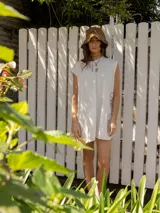 Vestido corto gris con bordado de flores en el frente.