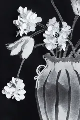 Remera negra de algodón con cuello redondo y mangas cortas. Estampado frontal con un jarrón con flores en blanco y negro.