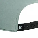 Gorra snapback color gris oscuro, con visera plana y paneles laterales y traseros perforados para ventilación. Presenta el logo de Hurley bordado en negro en el panel frontal.