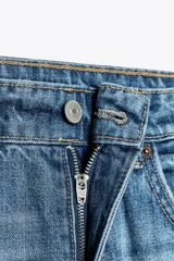 Pantalón de jean azul de corte wide leg, tiro medio y largo hasta el tobillo. Presenta roturas y detalles desgastados.