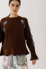 Sweater marrón de punto con cuello redondo y mangas largas con aberturas y aplicaciones de denim azul.
