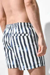 Short de baño blanco con rayas verticales azules, cintura elástica con cordón ajustable, bolsillos laterales y bolsillo trasero con cierre autoadherente. Cuenta con suspensor interior de malla suave.