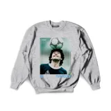 Buzo gris de algodón con estampa de Diego Maradona con la camiseta de la selección argentina y un balón en la cabeza. Incluye el texto "Maradona" y el número "86".