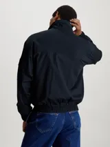 Campera negra con cierre frontal, cuello alto, puños y cintura elastizados. Presenta el logo de Calvin Klein Jeans en el brazo izquierdo. Corte relaxed.