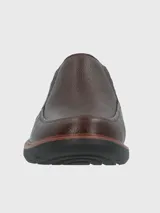 Zapato de cuero color marrón, estilo mocasín, con elásticos laterales y suela de goma EVA.