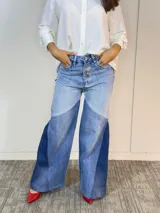 Pantalón de jean acampanado con cintura alta y diseño patchwork en tres tonos de azul.