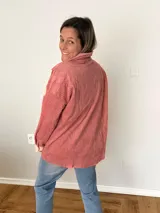 Sobrecamisa de pana texturada color rosa con detalles en tono más claro, corte oversize, bolsillos frontales aplicados y cierre frontal con botones.