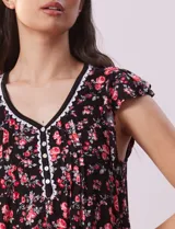 Camisón corto negro con estampado de lunares blancos, escote en V con puntilla blanca y botones.