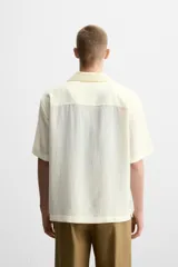 Camisa de hombre relaxed fit con cuello bowling y manga corta, confeccionada en tejido fluido con mezcla de viscosa a rayas verticales en tonos verde y blanco.