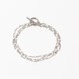 Pulsera plateada de tres hilos con cuentas blancas y cierre de gancho.