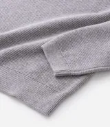 Suéter de punto color gris, con cuello redondo, manga larga y textura maquinetada.
