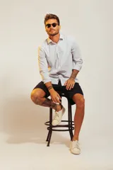 Camisa blanca de vestir con finas rayas verticales celestes, de corte clásico y manga larga.