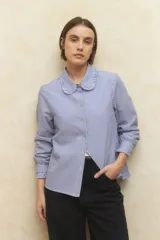 Camisa de manga larga a rayas, con cuello y puños con volados, confeccionada en algodón.
