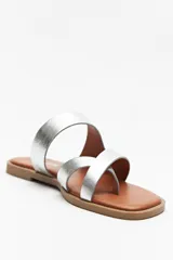 Sandalias bajas doradas con capellada de cuero sintético y agarre para el dedo gordo.