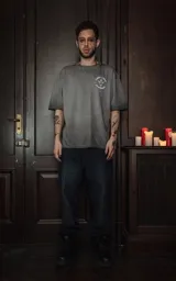 Remera gris de manga corta y cuello redondo, con calce oversize y estampado sublimado de una ilustración con una mujer, espadas y rosas.