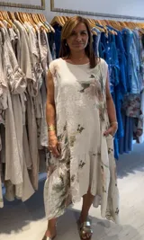 Vestido largo sin mangas, con escote a la base y estampado floral. Presenta un volado en el ruedo.