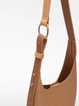 Bandolera pequeña color tostado, con textura granulada, un compartimento y cierre magnético. Tiene asa larga regulable y logo grabado.