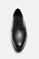 Zapato de vestir marrón tipo derby, con parte superior lisa, horma en punta y suela con ligero tacón.
