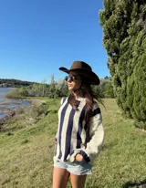 Sweater de lana color crema con rayas verticales anchas color amarillo mostaza, de corte holgado y cuello redondo. Tejido a mano.