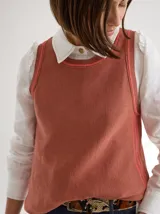 Chaleco tejido color ladrillo, de corte relajado con detalles en contraste color rosa en cuello y sisas.