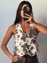 Chaleco con estampado de vaca, con cuello en V y cierre frontal con botones.