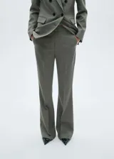 Pantalón de vestir gris con corte flare, tiro medio, bolsillos laterales y traseros.