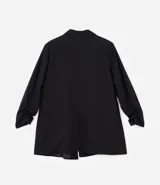 Blazer alargado color marrón, confeccionado en crepé de viscosa, sin cierre y con mangas fruncidas.