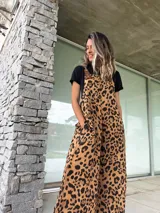 Mono largo de lino color marrón con estampado animal print de leopardo. Tiene tirantes de cuero marrón con hebillas metálicas y bolsillos laterales.