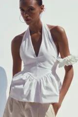 Top blanco de cuello halter y escote pico. Tejido combinado a tono. Bajo acabado tipo globo.